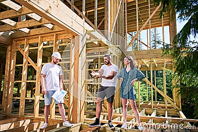 Man designer with plan showing the process of constructing wooden framed house. Stock Photo