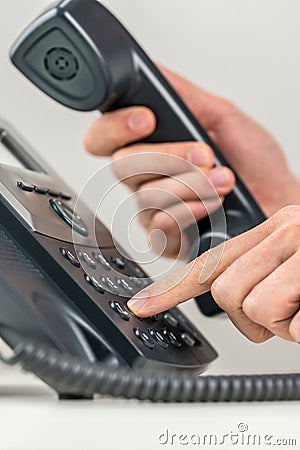 Man dialing out on a landline telephone Stock Photo