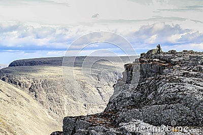 A man in the distance makes a photo of mountains among the Khibiny rock in Karelia, Russia. Stock Photo