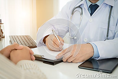 Man doctors and patient are discussing something for consultation. Medical Doctor working in hospital writing Stock Photo