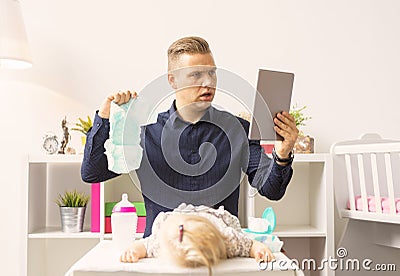 Man doesn`t know how to change diapers Stock Photo