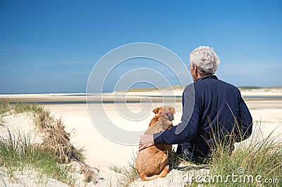 Man with dog on sand dune Stock Photo