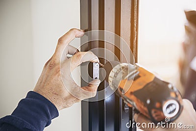 Man doing aluminum frame with glasses and wire screen door and window Stock Photo