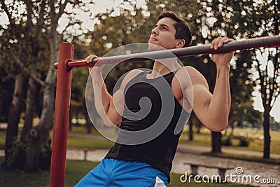 Man doing chin ups on the bar in the park Stock Photo