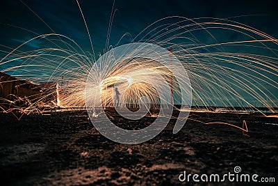 Man doing a circular spinning light using steel wool at night Stock Photo