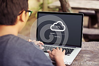 Man doing cloud uploading on laptop / computer Stock Photo