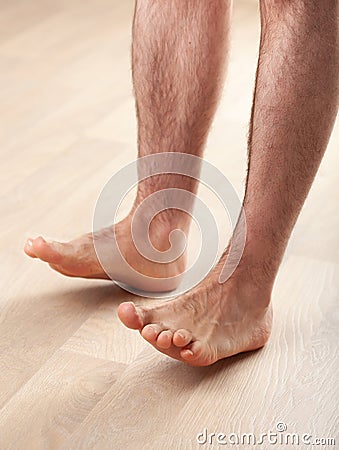 Man doing flatfoot correction gymnastic exercise toe lifts at home Stock Photo