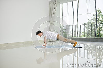 Man doing plank exercise at home - Image Stock Photo