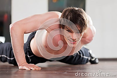 Man doing pushups in gym Stock Photo