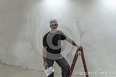 Man doing repairs, finishing room, plasterers, puttied and painted walls Stock Photo