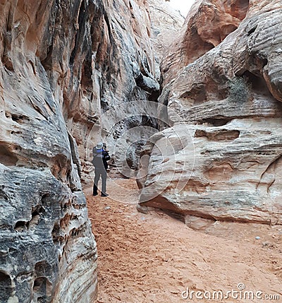 Man trekking through blue rock cavern around White Rock in Valley of Fire State Park Stock Photo