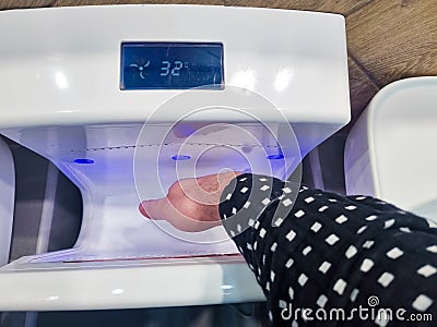 a man dries hands in the electric dryer of a public toilet. Stock Photo