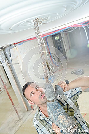Man drilling ceiling rose Stock Photo