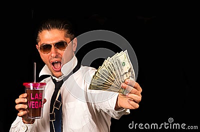 Man drinking a cocktail and showing money Stock Photo