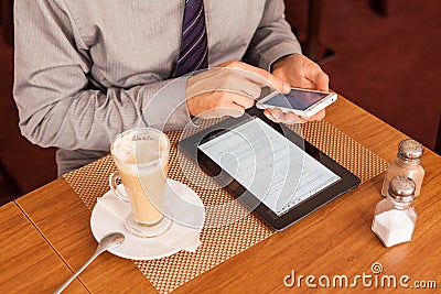 Man drinking coffee and using tablet and mobile Stock Photo