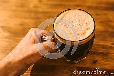 Man drinking dark beer in british dimpled glass pint mug Stock Photo