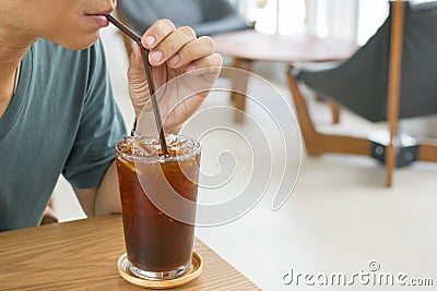 Man drinking a glass of ice americano. Stock Photo