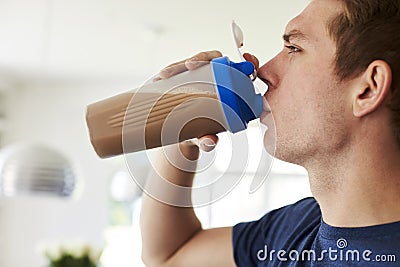 Man Drinking Protein Shake In Kitchen At Home Stock Photo