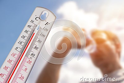 Man drinking water in extreme heat, Thermometer in summer day shows or indicate high temperature Stock Photo