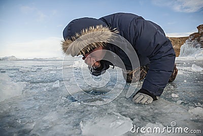 Man drinking water from a hand hole of lake Stock Photo