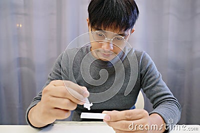 A man is dripping with a solution that has undergone a process of mixing COVID-19 tests Stock Photo