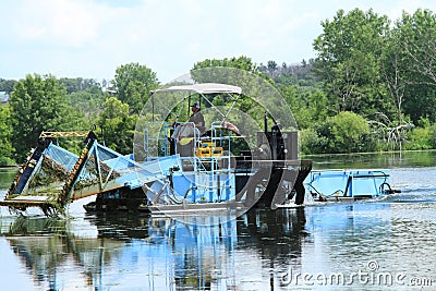 Man drives a lake vegetation harvester Stock Photo