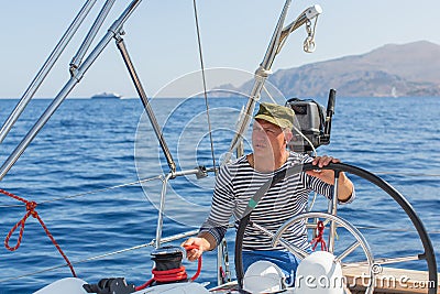 Man drives sailing yacht at the sea. Stock Photo