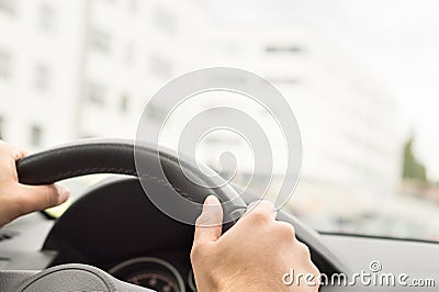 Man driving car in city. Driver holding steering wheel. Stock Photo
