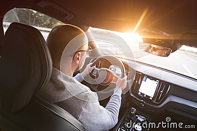 Man driving a car. Success in motion. Handsome young man driving a car. A man holds the steering wheel of a car Stock Photo