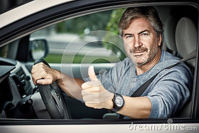 Man driving car with thumb. Stock Photo