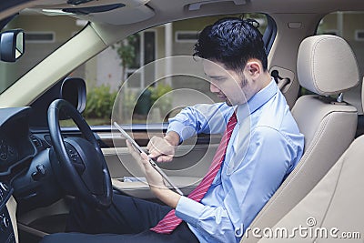 Man driving checks digital tablet for locating an address Stock Photo