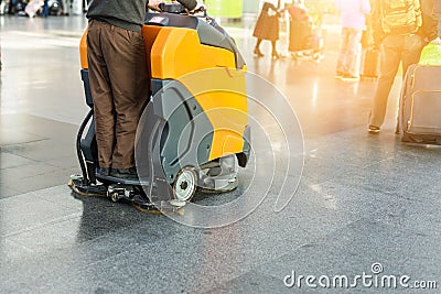 Man driving professional floor cleaning machine at airport or railway station. Floor care and cleaning service agency Stock Photo