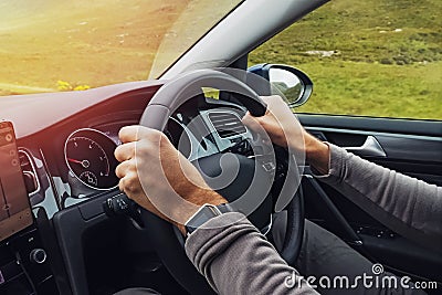 Man driving right hand car. Close-up shot of man`s hands holding steering wheel. Stock Photo