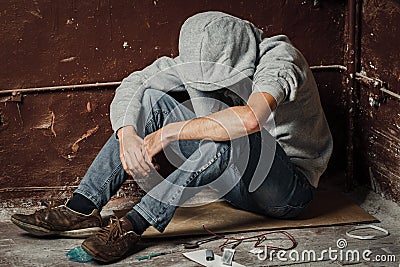 A man is a drug addict with a syringe using drugs lying on the f Stock Photo