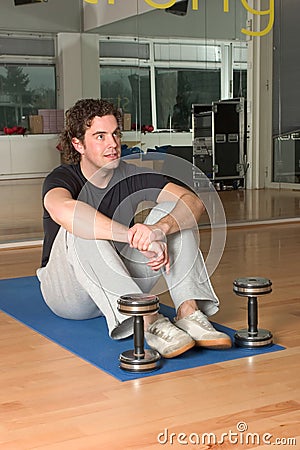 Man with dumbbels on exercise mat Stock Photo