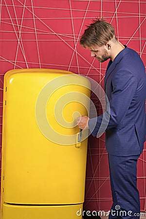 Man on duty near fridge. Stop being hungry. Beginning of diet. On guard your diet. Guy handsome formal suit near fridge Stock Photo