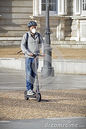 Man on e-scooter with mask Editorial Stock Photo
