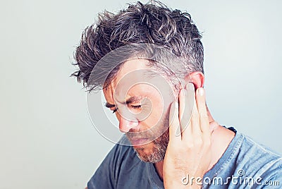 Man with earache is holding his aching ear pain concept Stock Photo