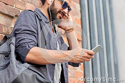 Man with earphones, smartphone and bag on street Stock Photo