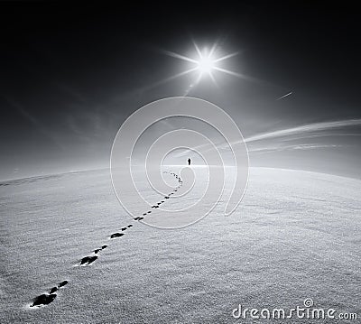 Man.Earth.Universe.Lonely man walking on snow crust field on the trail of a hare on the background of the sun and the flying plane Stock Photo