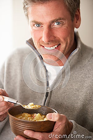 Man eating bowl of soup Stock Photo