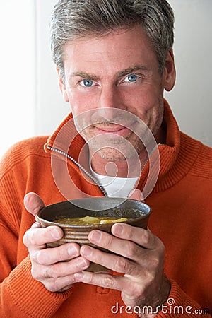 Man eating bowl of soup Stock Photo