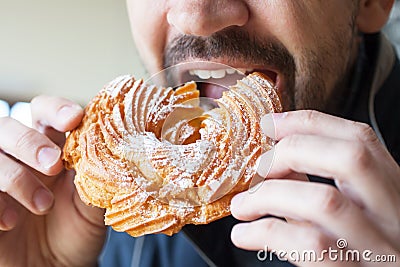Man is eating a custard ring - a traditional Russian dessert Stock Photo