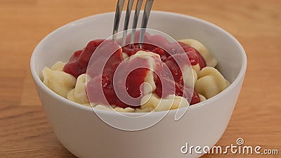 Man eating dumplings with ketchup a fork. Close up Stock Photo