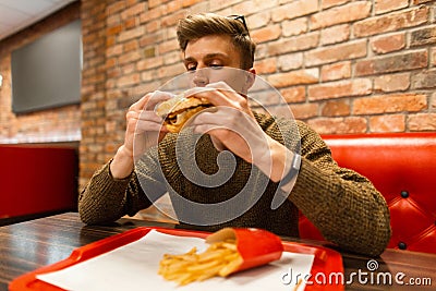 Man eating fast food in a cafe Stock Photo
