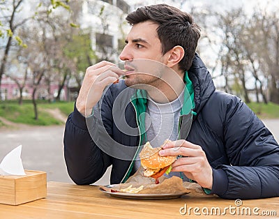 Man is eating French fries in a snack bar Stock Photo