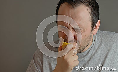 Man eating lemon and making silly faces Stock Photo
