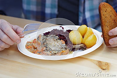 Man eating roasted duck with red cabbage and potato Stock Photo
