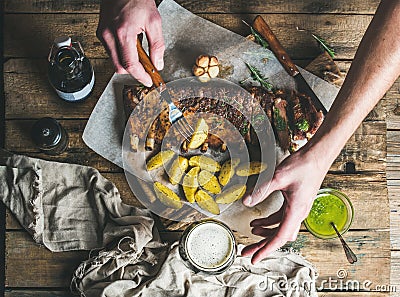 Man eating roasted pork ribs with garlic, holding fork Stock Photo