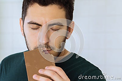 Man eats chocolate with great pleasure Stock Photo